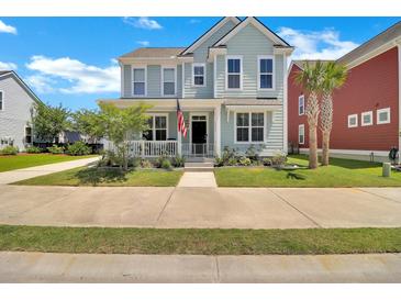 Charming two-story home with a welcoming front porch, landscaped yard, and an American flag at 2842 Rutherford Way, Charleston, SC 29414