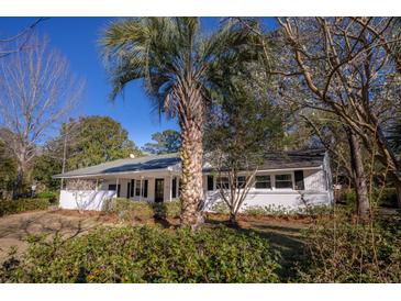 Charming single story home featuring a well-manicured lawn and a beautiful palm tree, providing a warm and inviting curb appeal at 412 Arlington Dr, Charleston, SC 29414
