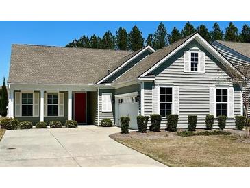 Charming single-story home boasts a well-manicured lawn, light gray siding and a red door at 572 Tidewater Chase Ln, Summerville, SC 29486