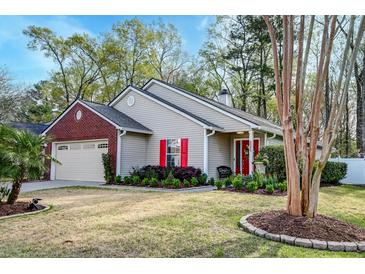 Charming single-story home featuring a well-manicured lawn, complemented by vibrant red shutters and a brick-accented garage at 8095 Old London Rd, North Charleston, SC 29406