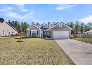 Charming single-Gathering home with a well-manicured lawn and a two-car attached garage at 1144 Wading Point Blvd, Huger, SC 29450