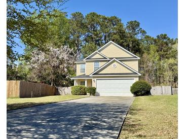 Charming two-story home with a two-car garage and well-maintained landscaping, set against a backdrop of lush trees at 148 Saint Charles Way, Goose Creek, SC 29445