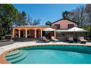 Inviting backyard pool with tanning ledge and patio with lounge chairs and umbrellas at 2014 Ion Ave, Sullivans Island, SC 29482