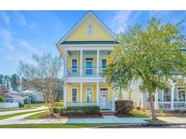 Charming yellow two-story home with a welcoming front porch and well-manicured landscaping at 401 Forsythia Ave, Summerville, SC 29483
