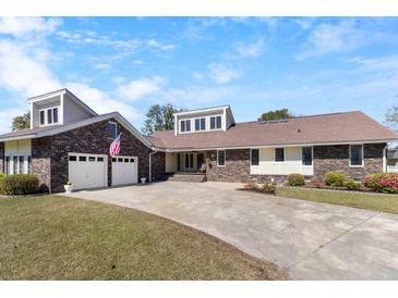 Charming brick home with two-car garage, well-manicured lawn, and a spacious driveway at 5286 Waterview Dr, North Charleston, SC 29418