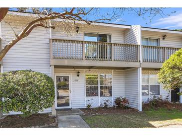 Charming townhome featuring a second-story balcony, neutral siding, and well-kept landscaping at 7875 Sandida Ct, North Charleston, SC 29418