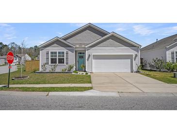 Charming one-story home features a teal front door, light gray siding, attached garage, and a well-manicured lawn at 9700 Flooded Field Drive Dr, Ladson, SC 29456