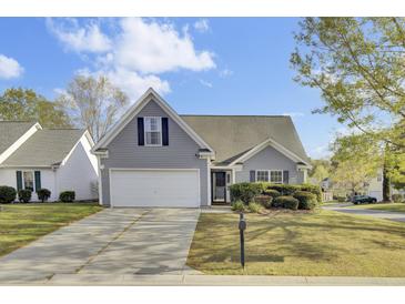 Charming home featuring a two-car garage, grey siding, manicured bushes, and a well-maintained lawn at 136 Rosario Dr, Summerville, SC 29483