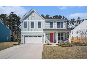 Charming two-story home with light blue siding, white trim, and a bright red front door at 1427 Homecoming Blvd, Ravenel, SC 29470
