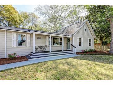 Charming home featuring a cozy front porch with seating and manicured landscaping at 1706 W Avalon Cir, Charleston, SC 29407