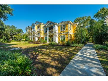 Beautiful yellow apartment building with a manicured lawn and a sidewalk leading to the entrance at 1928 Chatelain Way, Mount Pleasant, SC 29464