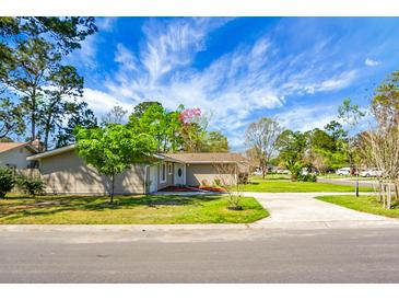 Well-kept home with an expansive front yard, healthy lawn, and lush landscaping under a brilliant blue sky at 201 Miami St, Ladson, SC 29456
