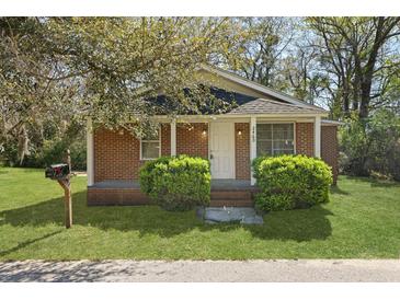 Charming brick home featuring a cozy porch and manicured front lawn, perfect for comfortable suburban living at 2460 Surprise St, North Charleston, SC 29405