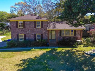 Charming brick two-story home featuring a well-manicured lawn and mature shade trees at 2467 Birkenhead Dr, Charleston, SC 29414