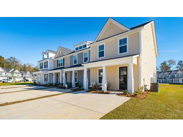 Charming new townhomes with driveways and landscaped front yards on a clear, sunny day at 314 Green Fern Dr, Summerville, SC 29483