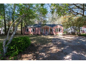 Charming single-story home featuring a welcoming front yard and a quaint exterior with a light pink facade and natural light at 708 S Laurel St, Summerville, SC 29483
