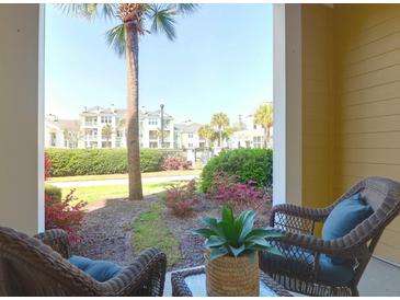 Inviting balcony with wicker furniture offers serene garden and community views at 1012 Rosewood Ln, Mount Pleasant, SC 29464