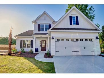Charming two-story home featuring a two car garage, a landscaped yard, and a welcoming front porch at 114 Seaton Street, Summerville, SC 29486
