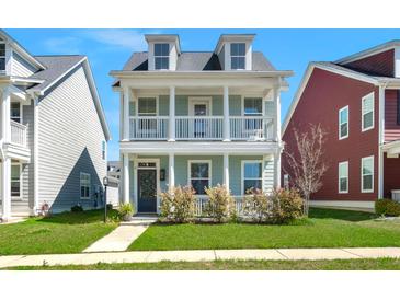 Charming two-story home with a covered front porch, white columns, and manicured landscaping at 122 Yorkshire Dr, Moncks Corner, SC 29461
