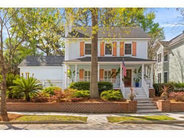 Charming two-story home with light blue exterior, colorful shutters, and inviting front porch landscaping at 205 Fairchild St, Daniel Island, SC 29492