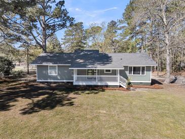 Charming one story home with white picket fence porch and natural landscaping at 212 Lake Moultrie Dr, Bonneau, SC 29431