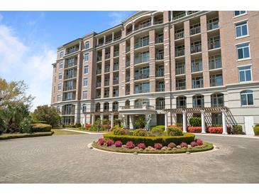 Brick apartment building showcasing manicured landscaping, roundabout, and elegant architectural details at 233 S Plaza Ct # 210, Mount Pleasant, SC 29464