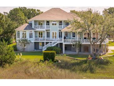 Beautiful elevated home with a porch and lush landscaping offers stunning curb appeal at 24 Waterway Island Dr, Isle of Palms, SC 29451