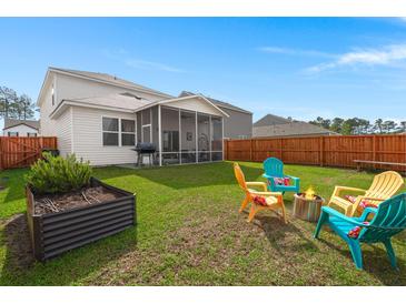 Expansive backyard featuring a cozy fire pit and a screened-in porch, perfect for outdoor entertaining at 315 Black Birch Dr, Summerville, SC 29486