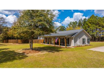 Charming home with a metal roof, welcoming front porch, and a spacious, well-manicured lawn at 508 Horse Trail Rd, Saint George, SC 29477
