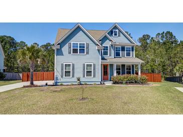 Charming two-story home with light blue siding, orange front door, manicured lawn, and mature landscaping at 5525 Alpine Dr, Summerville, SC 29483