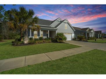 Charming single-story home featuring manicured lawn, palm trees, and a two-car garage at 566 Four Seasons Blvd, Summerville, SC 29486