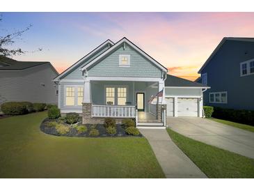 Charming single-story home featuring a welcoming front porch, manicured lawn, and a two-car attached garage at 804 Buckler St, Summerville, SC 29486
