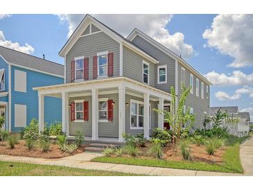 Charming two-story home featuring a welcoming front porch, gray siding, and vibrant red shutters at 820 Gentle Breeze Dr, Summerville, SC 29486