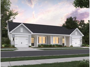 Charming duplex featuring a classic design with attached garages and a welcoming facade with manicured landscaping at 958 Dusk Dr, Summerville, SC 29486
