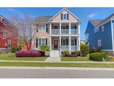 Charming two-story home featuring double balconies, well-manicured lawn, and a vibrant red front door at 2353 Eagle Creek Dr, Charleston, SC 29414