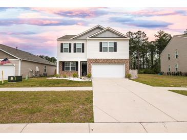 Two-story home featuring white siding and a brick facade, complemented by a well-manicured lawn and ample driveway space at 436 Cedarview Rd, Summerville, SC 29486