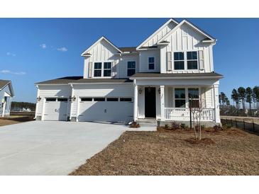 Charming two-story white home with a three car garage and inviting front porch at 752 Maynard Ln, Summerville, SC 29486