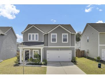 Charming two-story home boasts a well-manicured lawn and a two car garage at 85 Arrowwood Way, Summerville, SC 29485