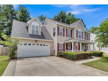 Charming two-story home with a two car garage, an American flag, and a well maintained lawn at 9360 S Moreto Cir, Summerville, SC 29485