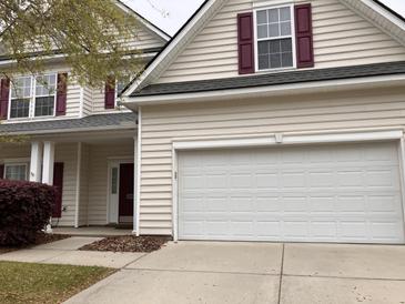 Two-story home featuring a two-car garage, red shutters, and light-colored siding at 9684 Pebble Creek Blvd, Summerville, SC 29485