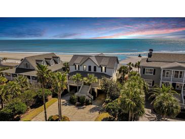 Stunning beachfront home with palm trees, offering breathtaking ocean views and a serene coastal lifestyle at 212 Ocean Blvd, Isle of Palms, SC 29451