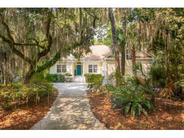 Charming home exterior featuring lush landscaping, mossy trees, and a inviting walkway to the front door at 2737 Old Forest Dr, Seabrook Island, SC 29455