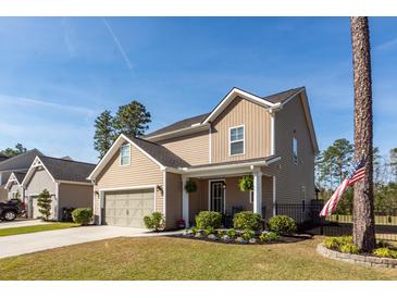 Inviting two-story home with a manicured lawn, attached garage, and a charming front porch, perfect for relaxing at 505 Kilarney Rd, Summerville, SC 29483