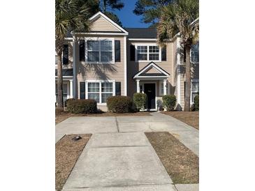 Charming two-story home with a well-maintained front yard and mature landscaping and a two car driveway at 9028 Maple Grove Dr, Summerville, SC 29485