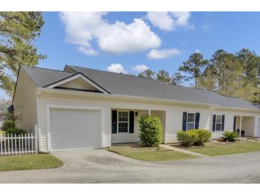 Charming exterior view with one-car garage, tidy landscaping, and classic white siding under a cloudy blue sky at 100 Bridgetown Rd # 10B, Goose Creek, SC 29445