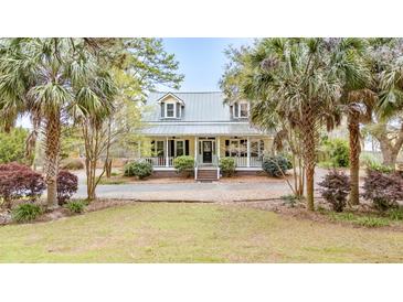 Charming two-story home with a welcoming front porch and well-manicured lawn, surrounded by lush trees at 1034 Orangeburg Rd, Summerville, SC 29483