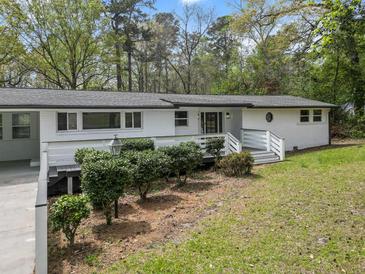 Charming white brick home with manicured landscaping and a welcoming front porch at 107 Woodland Dr, Summerville, SC 29485
