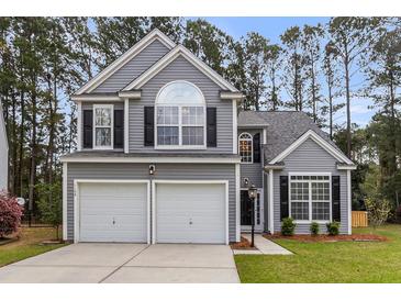 Charming two-story home boasts a well-manicured lawn, attached two-car garage, and classic architectural details at 1158 Peninsula Cove Dr, Charleston, SC 29492