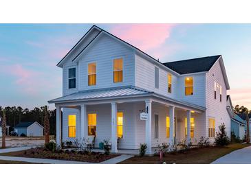 Charming two-story white home with a covered porch and beautiful architectural details at sunset at 1435 Clay Field Trl, Summerville, SC 29485