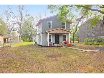 Charming two-story home featuring a quaint front porch, landscaped yard, and mature trees at 1617 Balsam St, Charleston, SC 29407